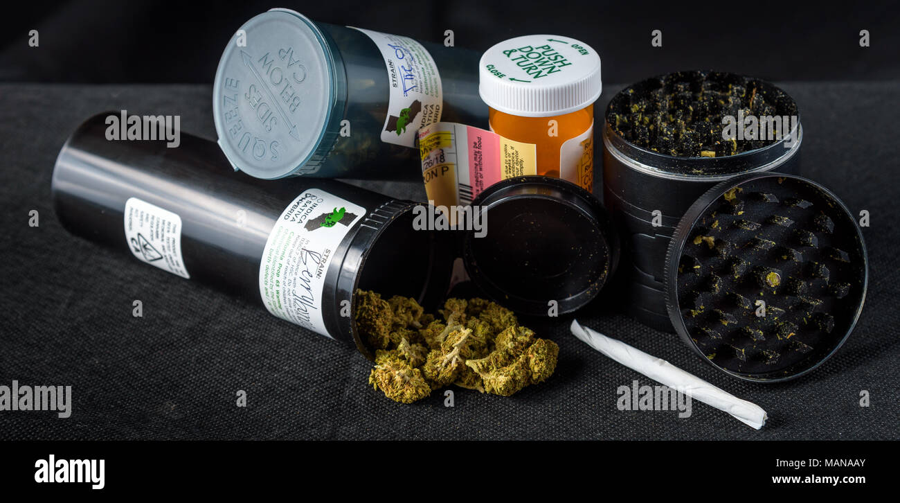 prescription bottles of medical marijuana tipped over with buds spilling out. Black background Stock Photo