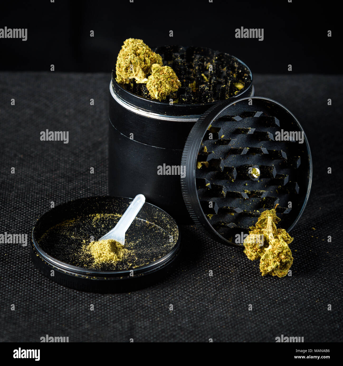 A medicinal marijuana grinder with keef and scraper. Black background Stock Photo