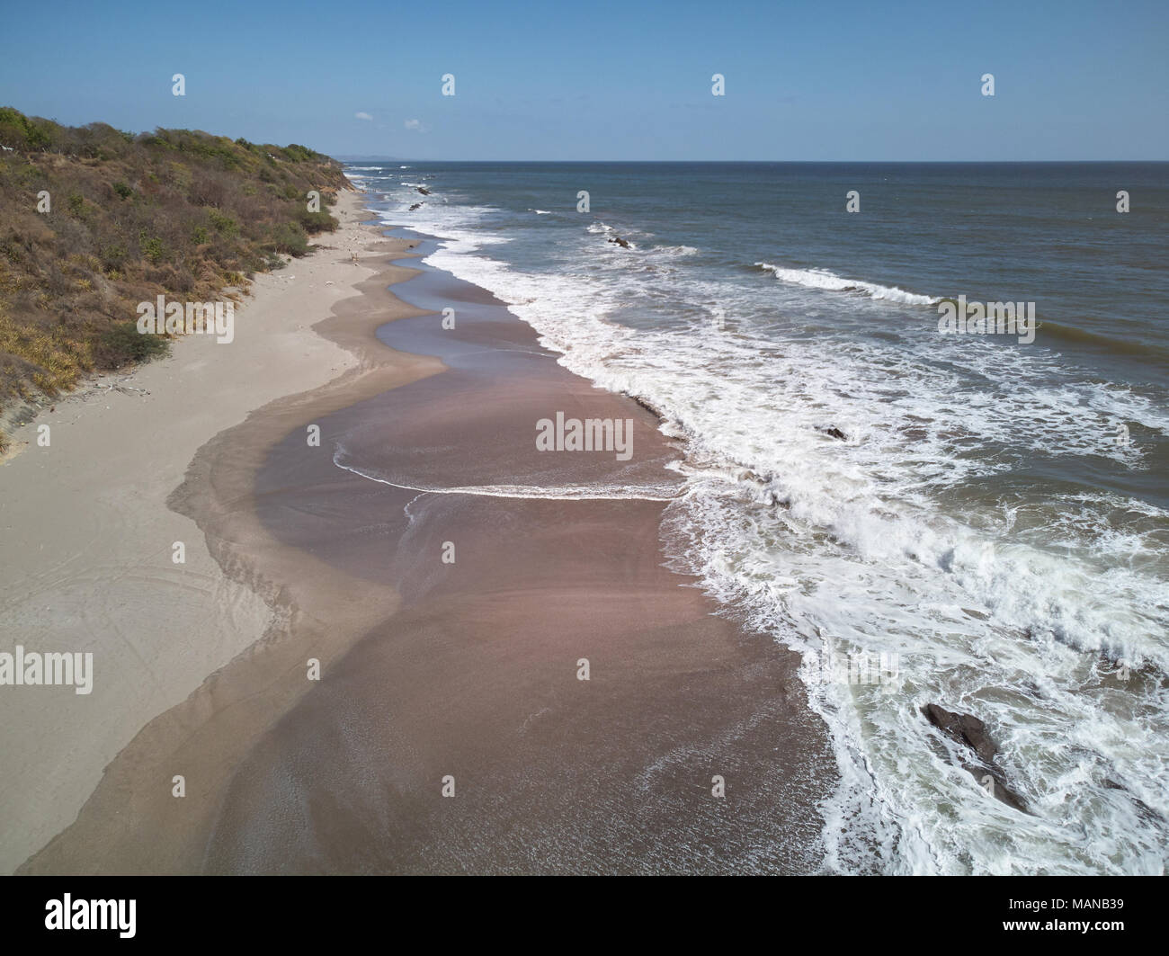 Ocean waves hit sandy beach aerial drone view Stock Photo