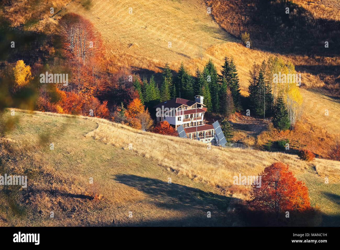 Mountain autumn landscape with colorful forest and traditional houses ...
