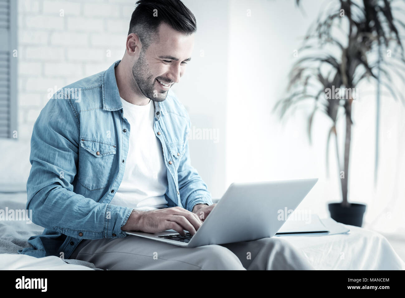 Happy positive man typing the text Stock Photo