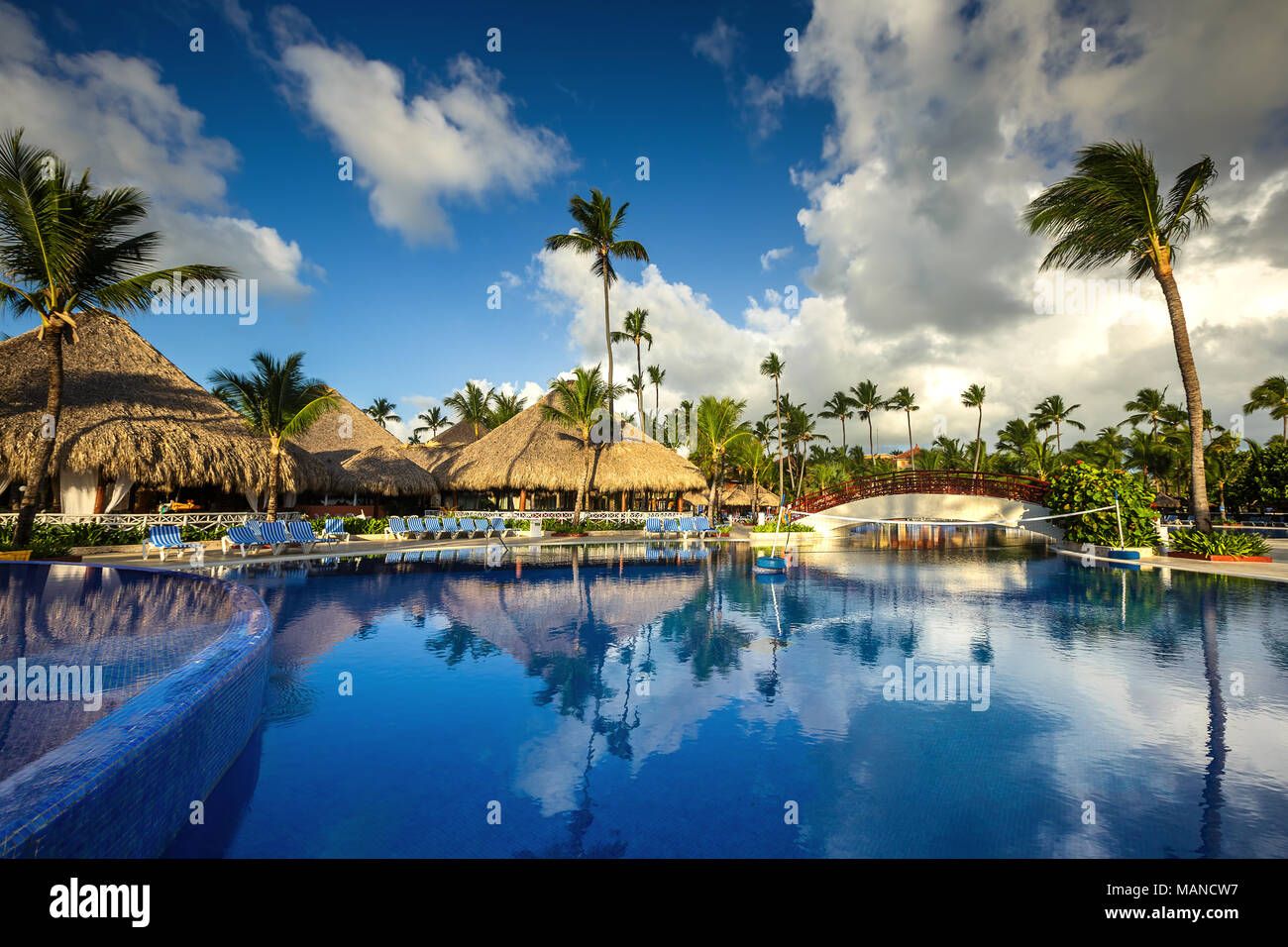 Tropical swimming pool and palm trees in luxury resort Stock Photo - Alamy
