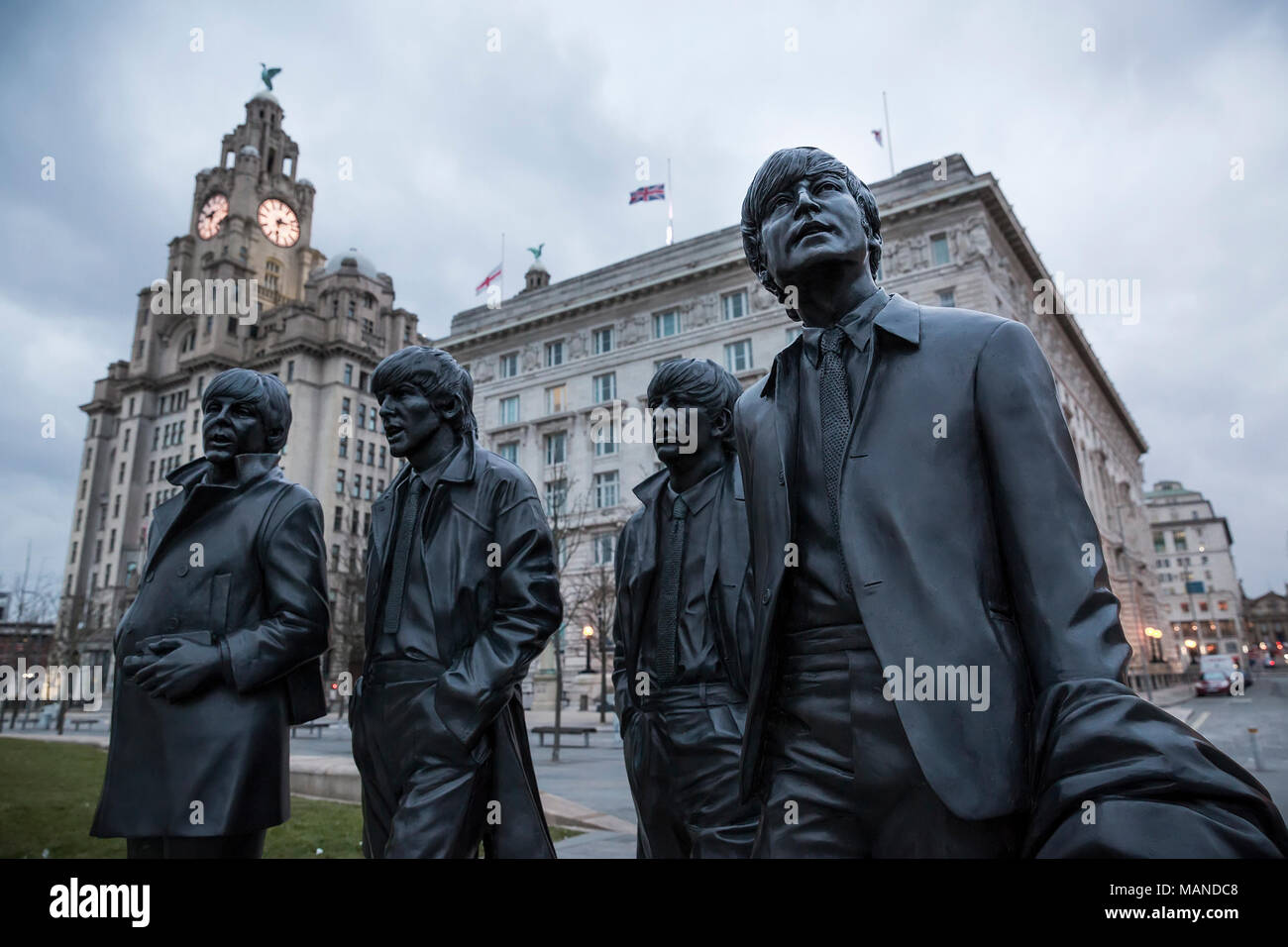 LIVERPOOL, UK - March 18, 2018 : Close up of the Beatles statues at the pier head in Liverpool with the Royal Liver Building in the background. Stock Photo