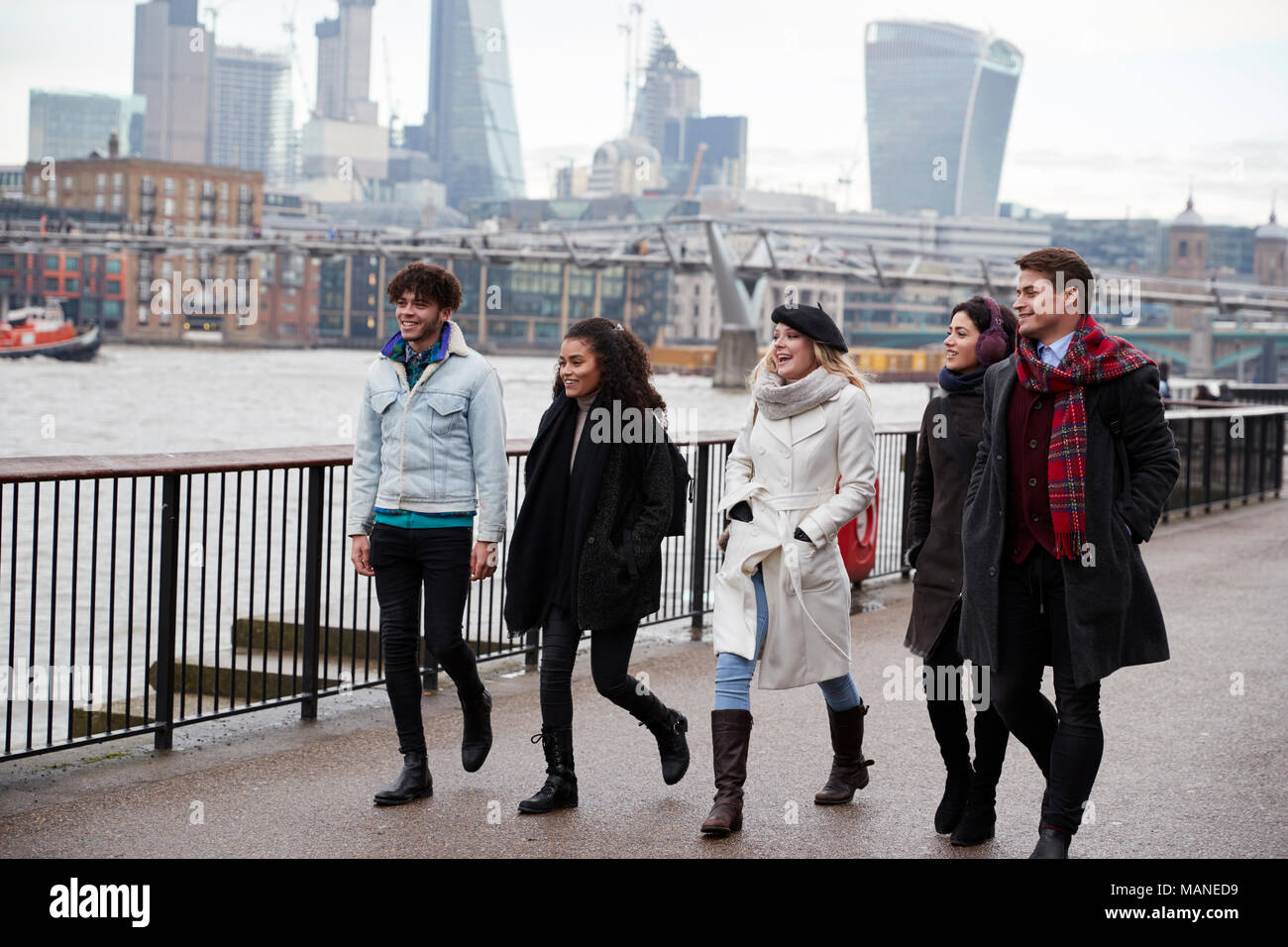 Friends Walking Along South Bank On Winter Visit To London Stock Photo