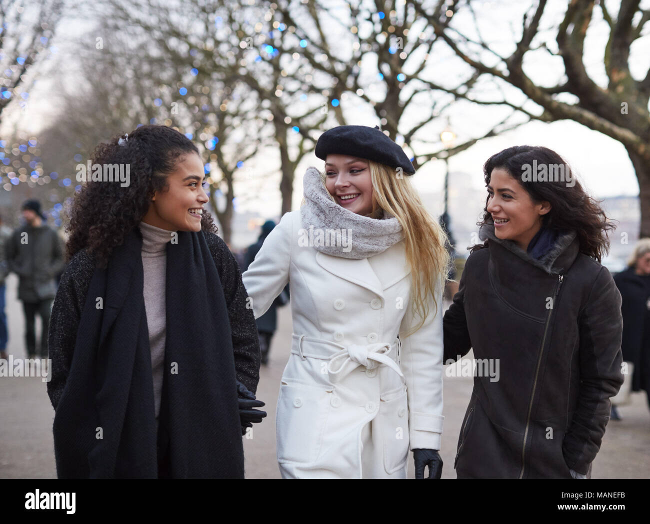 Female Friends Walk Along South Bank On Winter Visit To London Stock Photo