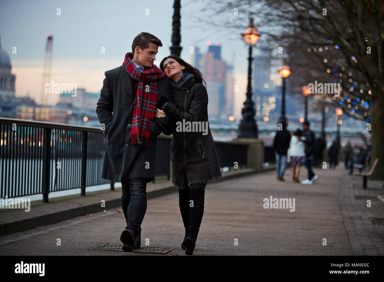 Couple Walking Along South Bank On Winter Visit To London Stock Photo