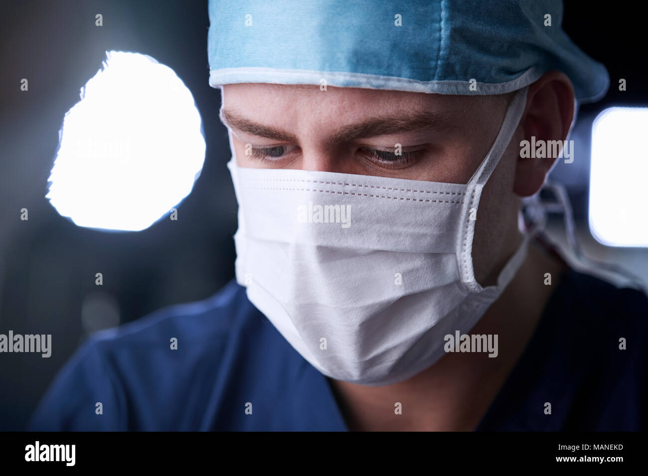 Male surgeon looking down, head and shoulders Stock Photo