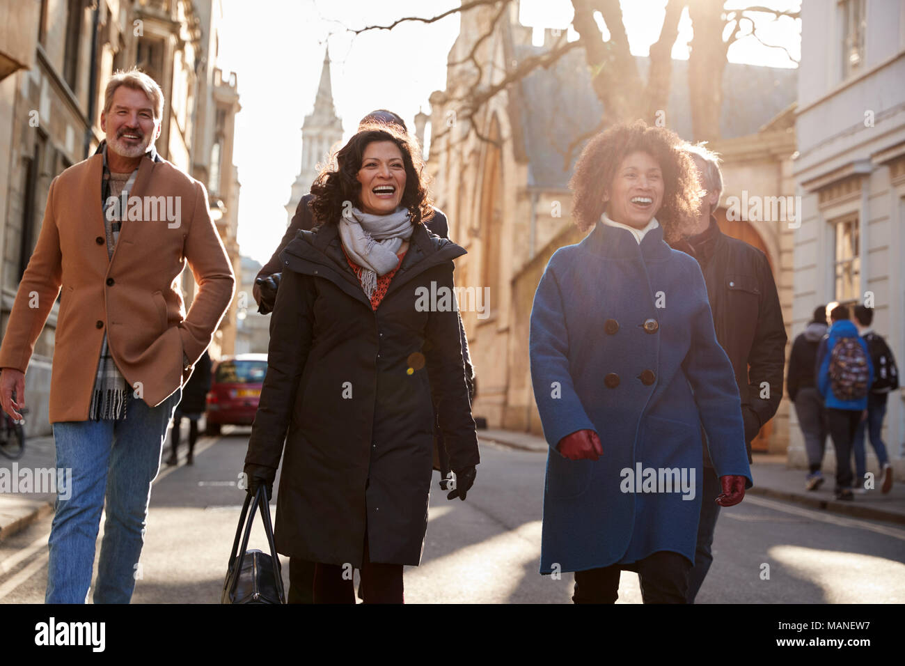 Group Of Mature Friends Walking Through City In Fall Together Stock Photo