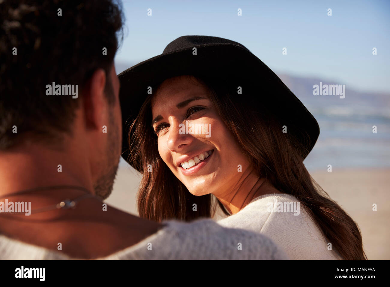 Romantic Couple Sitting On Winter Beach Together Stock Photo