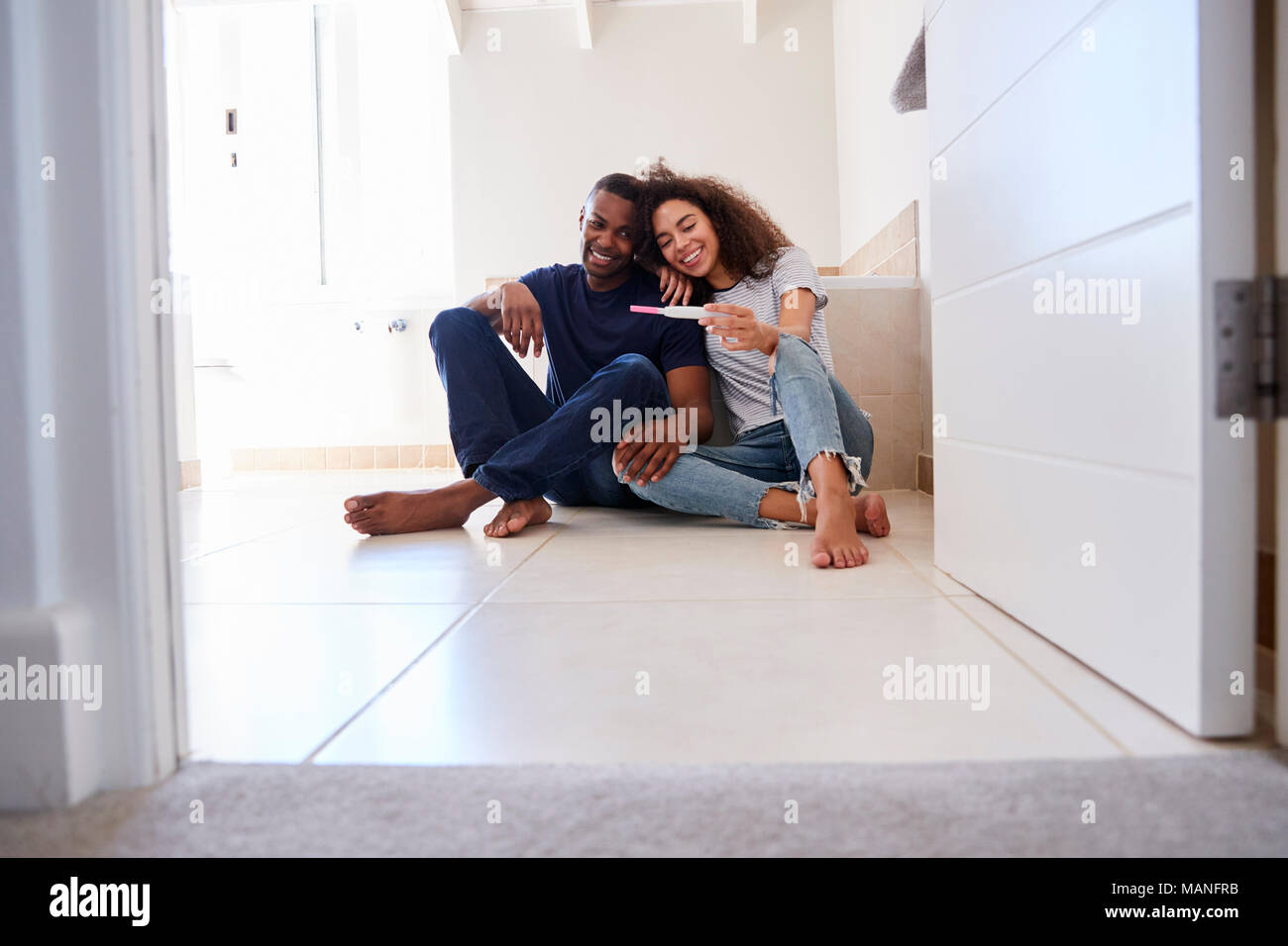 Couple Celebrating Positive Home Pregnancy Test Result Stock Photo