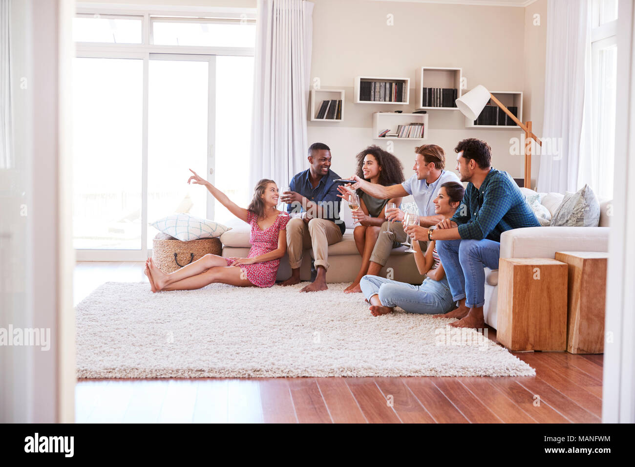 Group Of Friends Relaxing At Home Watching TV Together Stock Photo