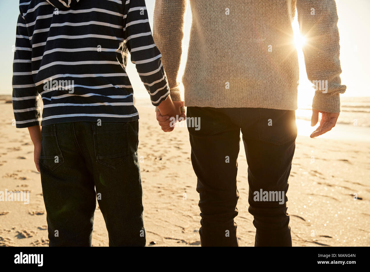 Detail Of Father And Son Walking Along Winter Beach Hand In Hand Stock Photo
