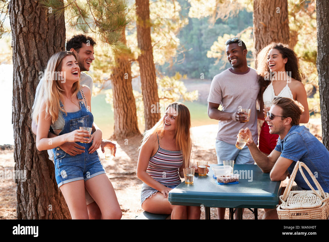 Group of adult friends hanging out by a lake, close up Stock Photo