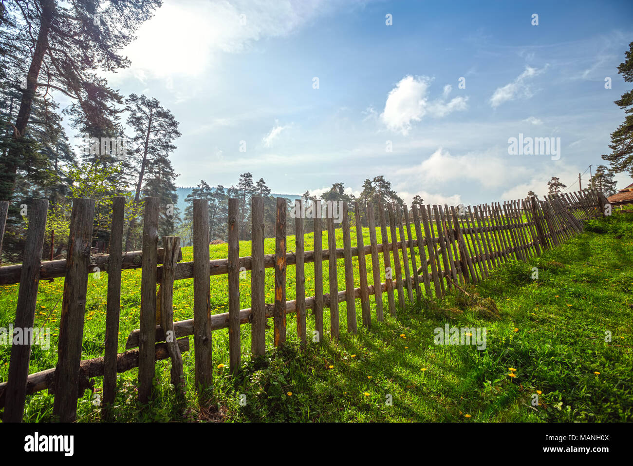 Fence in the green field under blue cloud sky Stock Photo - Alamy