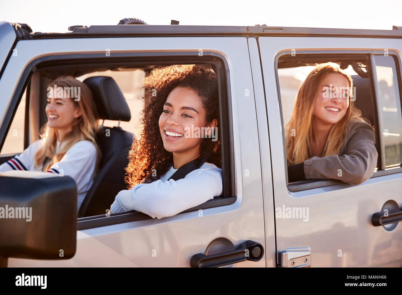 Young adult female friends going on vacation in a car Stock Photo