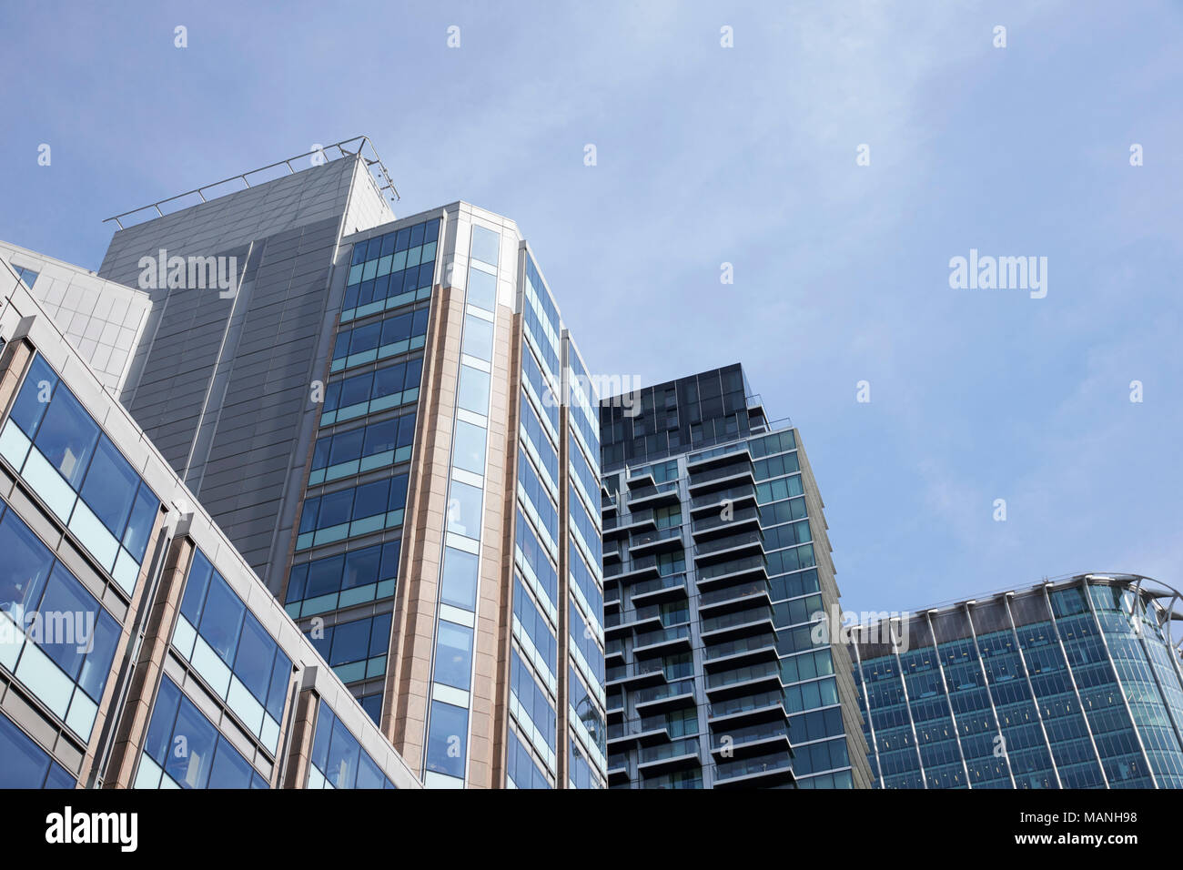 LONDON - MAY, 2017: Low angle view of modern glass fronted buildings against blue sky, City Of London, London Stock Photo