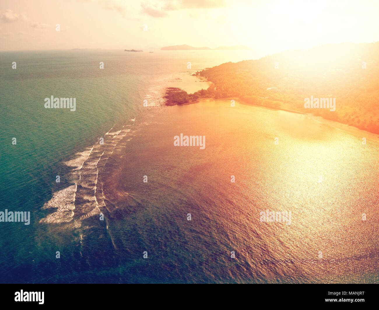Aerial view of sunset over emerald tropical sea Stock Photo
