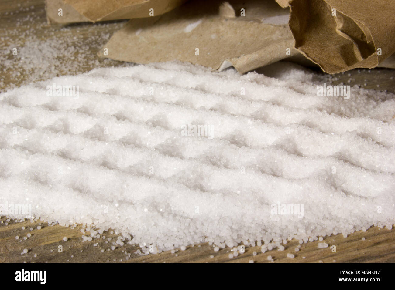 Small table Salt in Kraft box spilled on the wooden background Stock Photo