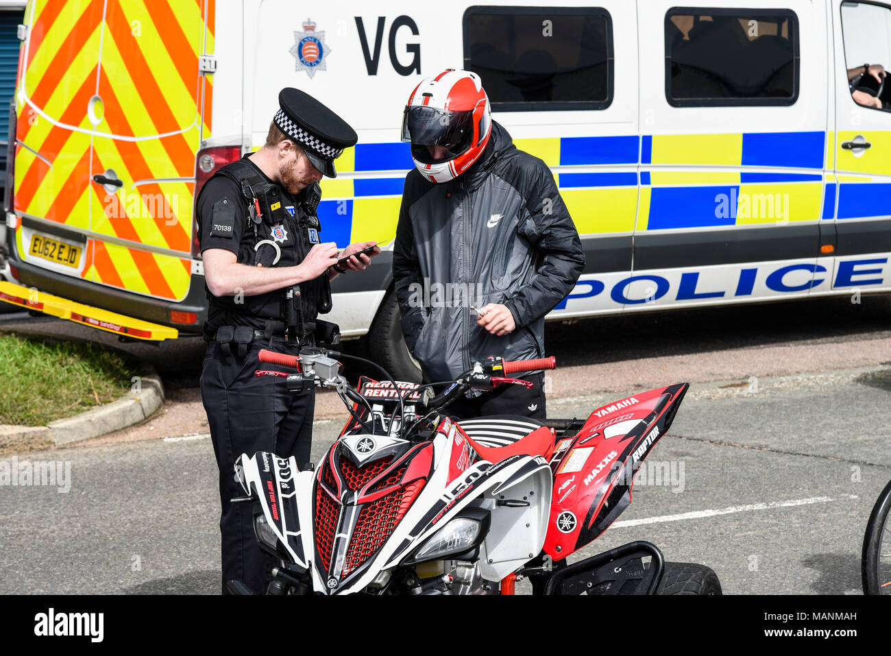 Quad bike rider pulled over by police for motoring offence. Police van. Policeman taking notes. Southend Shakedown motorbike unofficial event. Policed Stock Photo