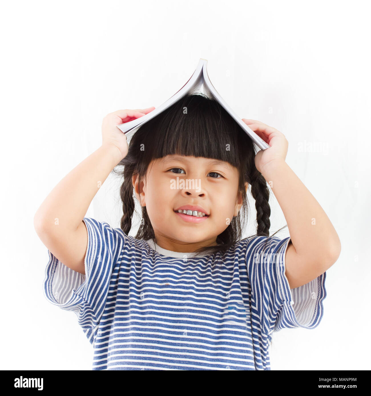 little girl with book over her head on white background Stock Photo - Alamy