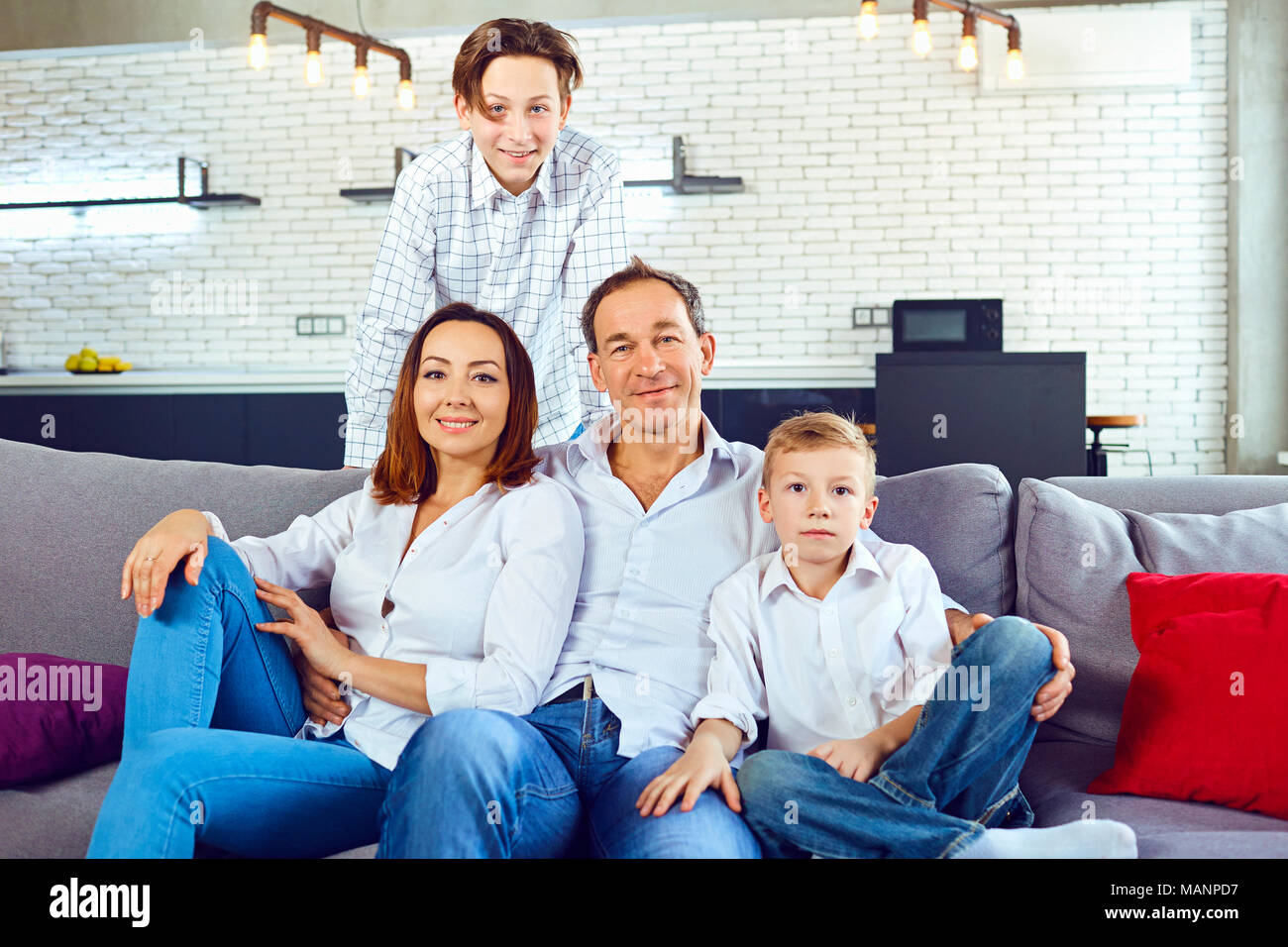 Family sitting on the couch hi-res stock photography and images - Alamy
