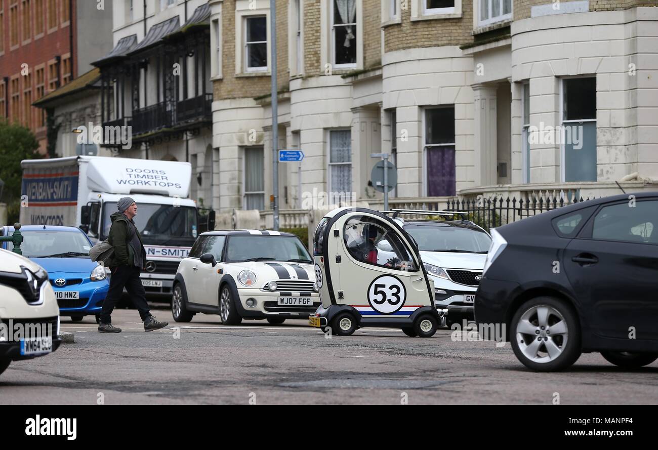 A Disability car painted to look like the famous VW Beetle Herbie crosses a busy road in Brighton. April 3 2018 Stock Photo