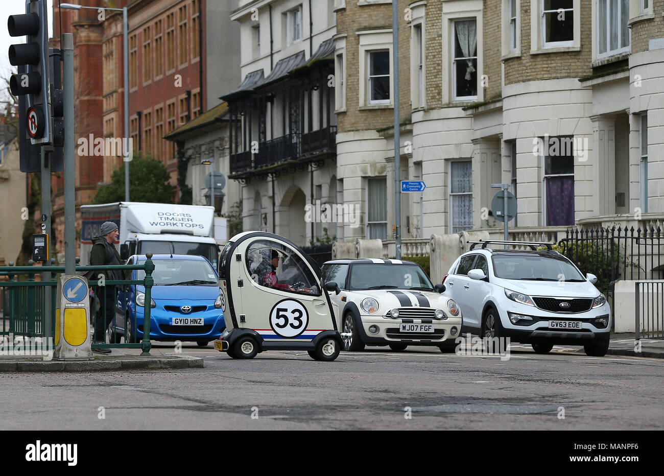 A Disability car painted to look like the famous VW Beetle Herbie crosses a busy road in Brighton. April 3 2018 Stock Photo