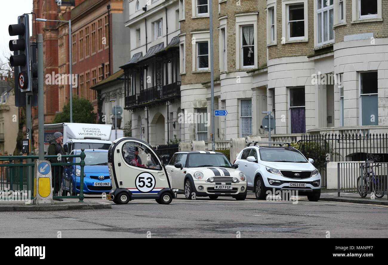 A Disability car painted to look like the famous VW Beetle Herbie crosses a busy road in Brighton. April 3 2018 Stock Photo