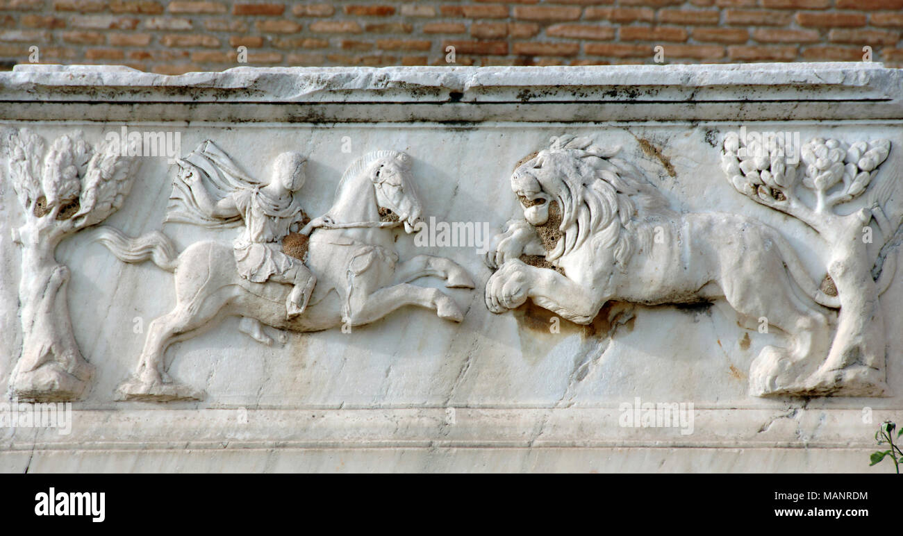 Roman relief. Detail from a tomb located at the Odeon. Soldier on horseback fighting a lion. Marbre. Patras, Peleponnese, Greece. Stock Photo