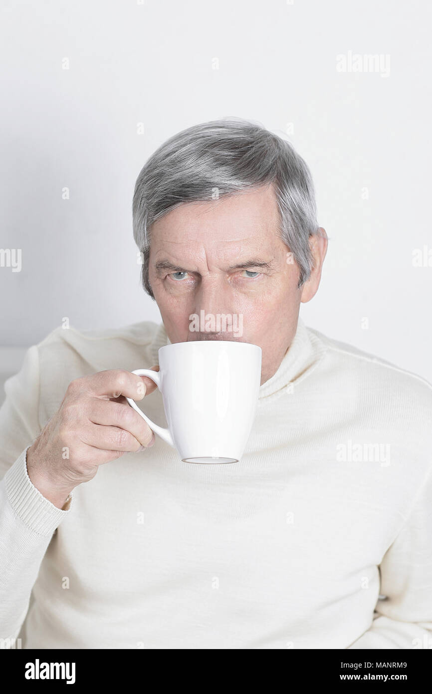 serious elderly man with a Cup of coffee.isolated on white Stock Photo