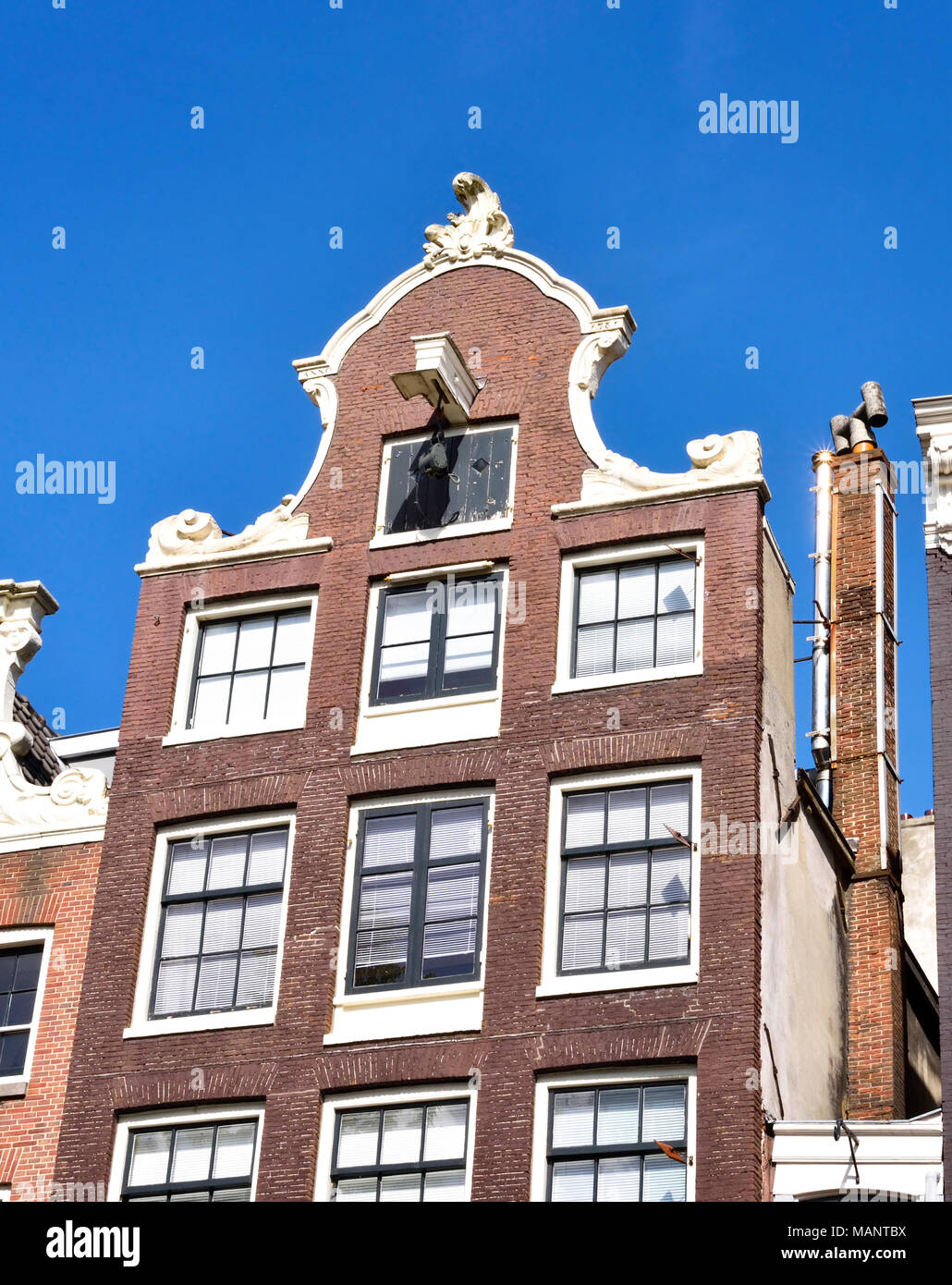 Town houses in Amsterdam, the Netherlands. Building exterior or house facade with blue sky. Stock Photo
