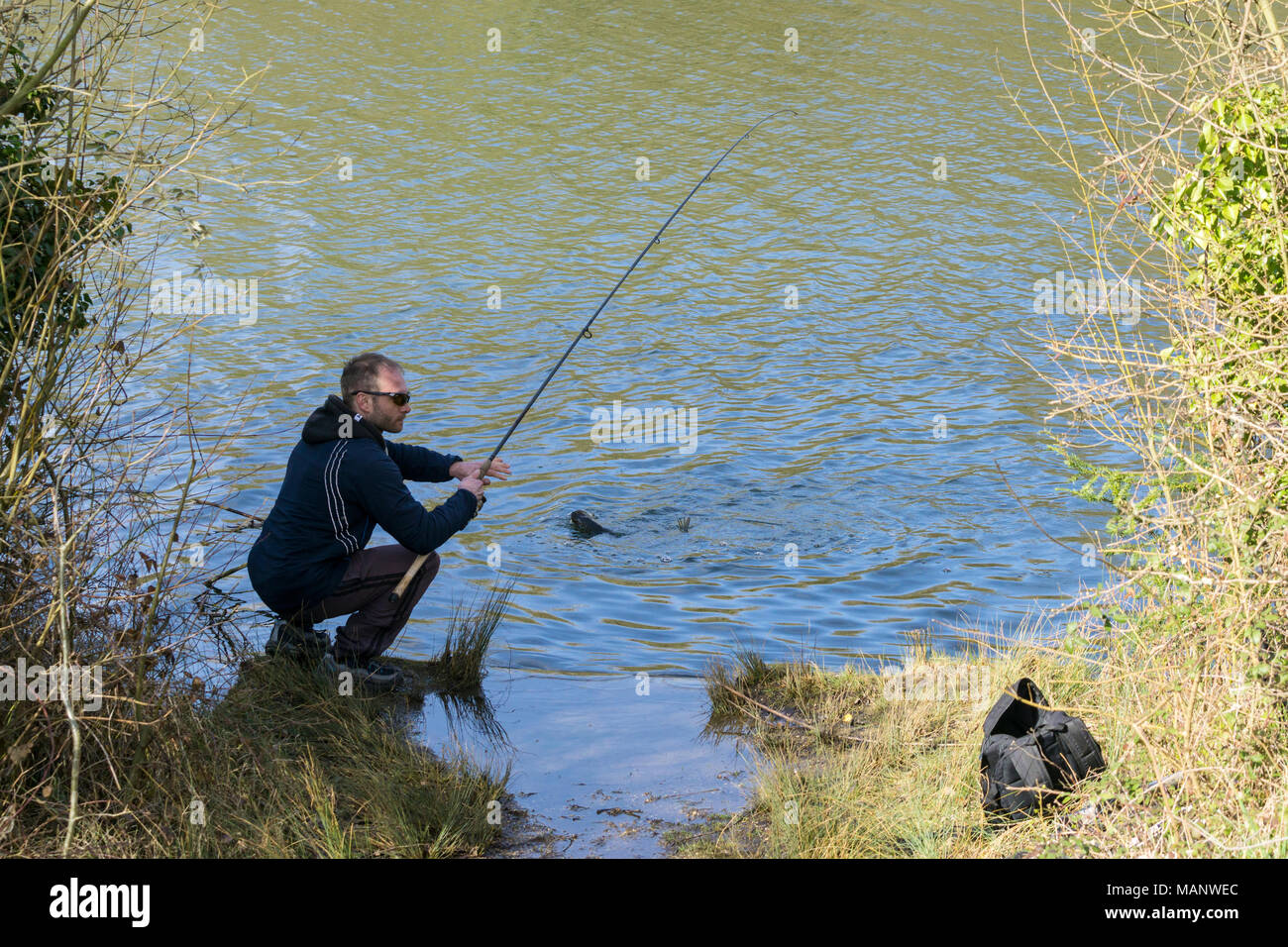 Angler with fish on hook Stock Photo