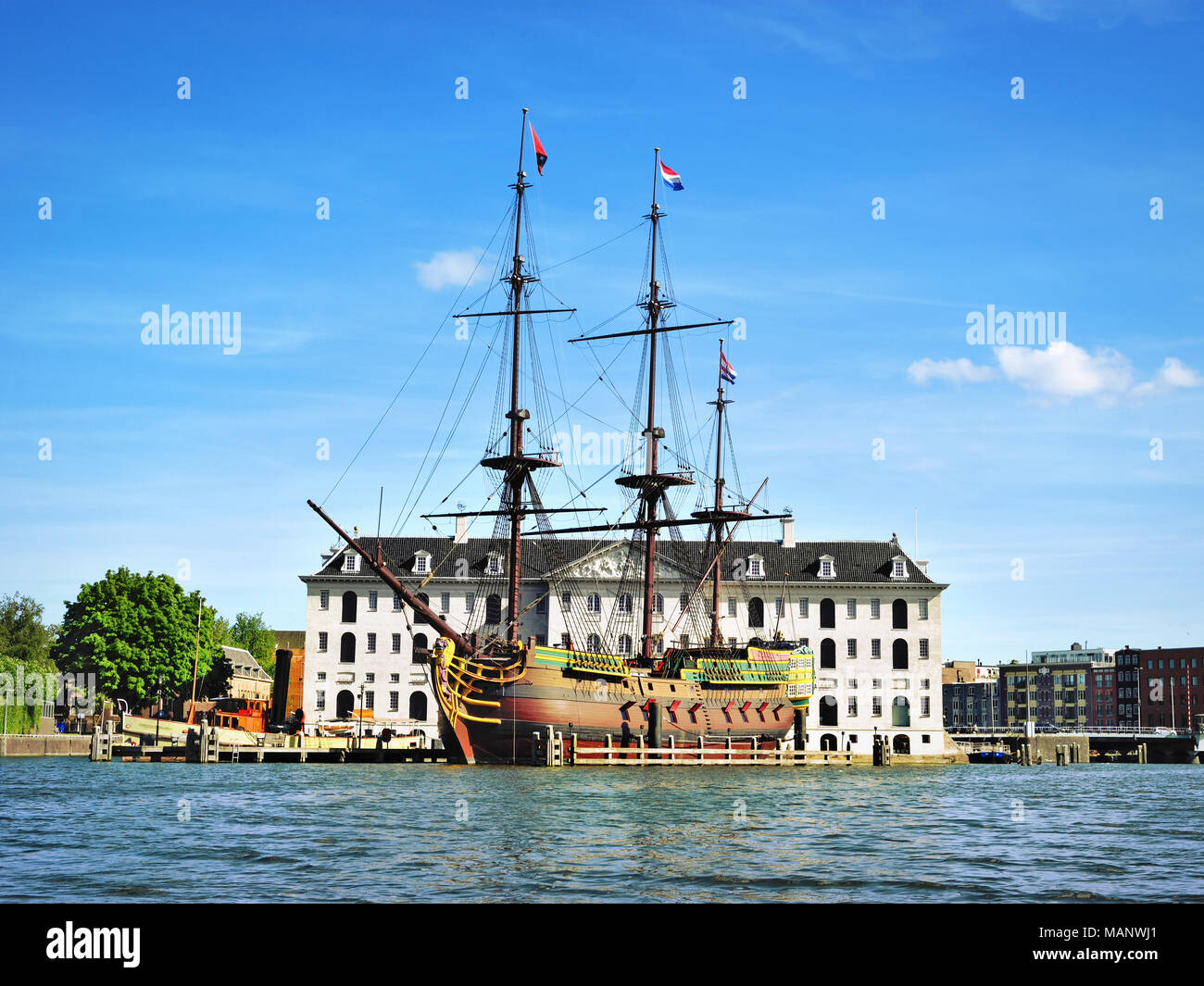 Pirate ship or wooden ship in front of an historical building in Amsterdam. Sightseeing attraction, antique ship. Stock Photo
