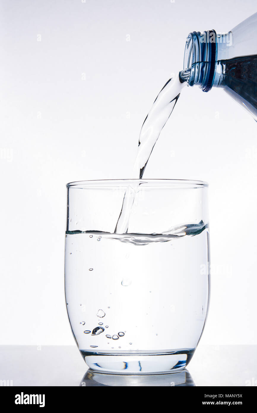 Bottle of water pouring water into a glass Stock Photo - Alamy