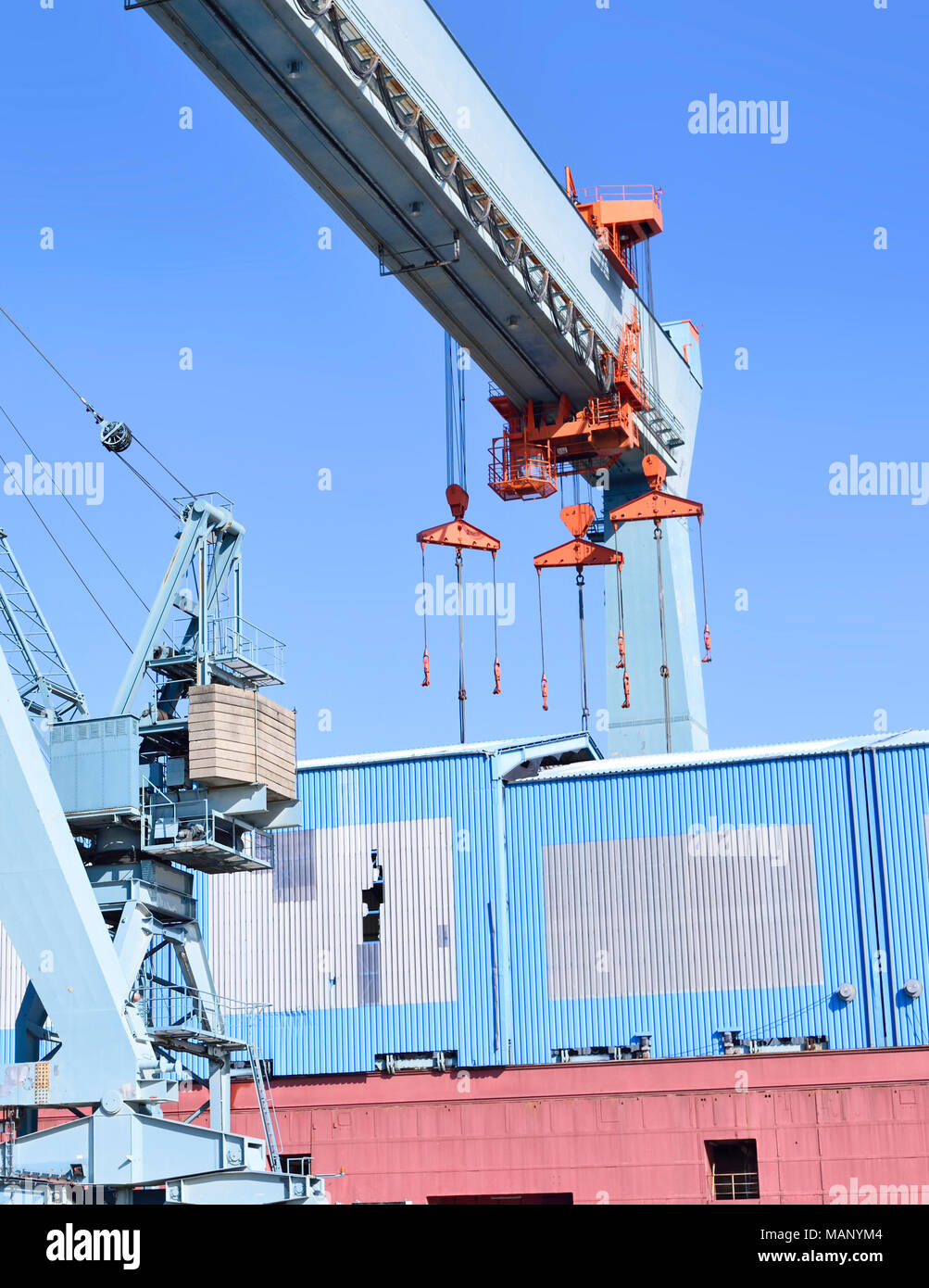 Container harbor with harbor cranes or freight cranes. Warf or cargo shipping scene, industrial transportation or shipping scene. Hamburg harbor. Stock Photo