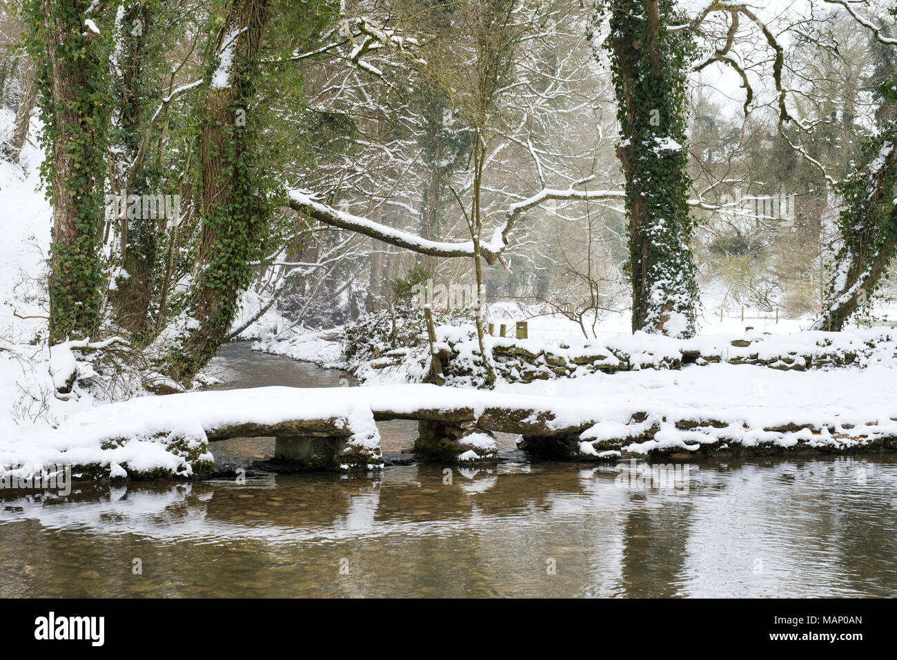 Ford and Clapper Bridge in winter snow on the river windrush at Kineton. Kineton, Gloucestershire, UK Stock Photo
