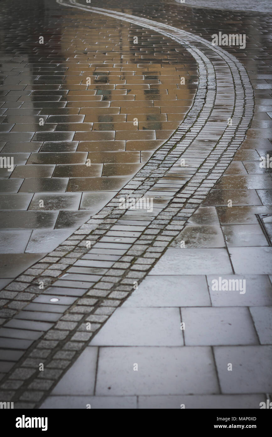 Reflections in rain soaked paving slabs Stock Photo