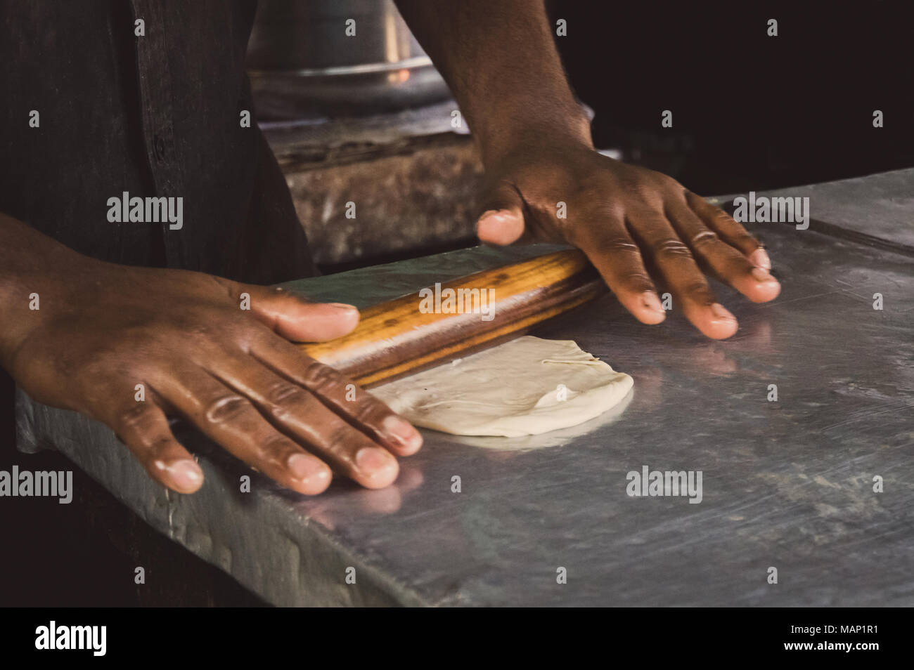 Men hands roll out dough close up. Asian men preparing dough for cooking local Indian Roti in the street market. Process to cooking most popular delic Stock Photo