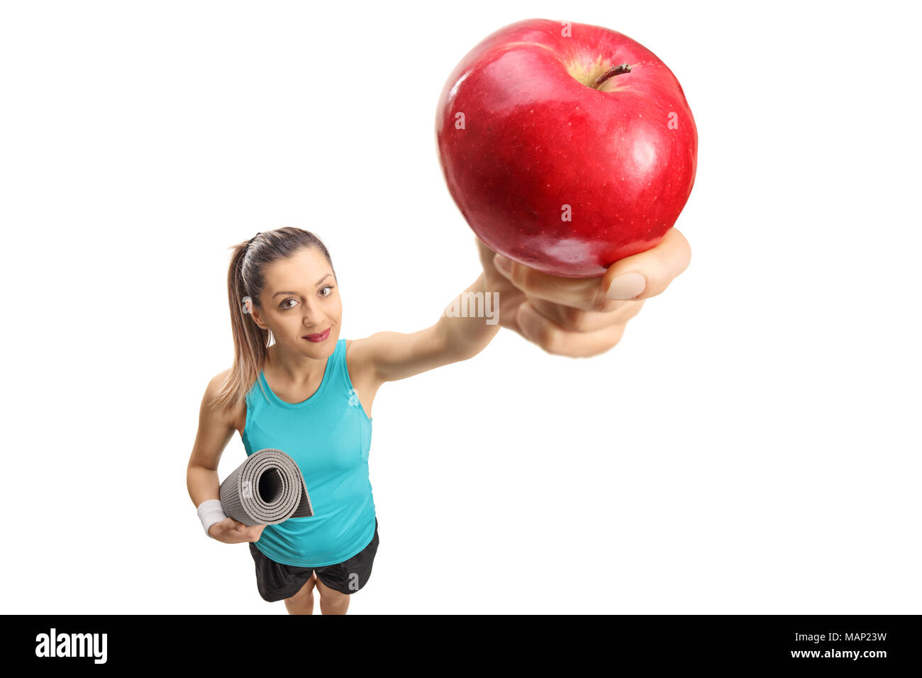 Fitness woman with an exercise mat and an apple isolated on white background Stock Photo