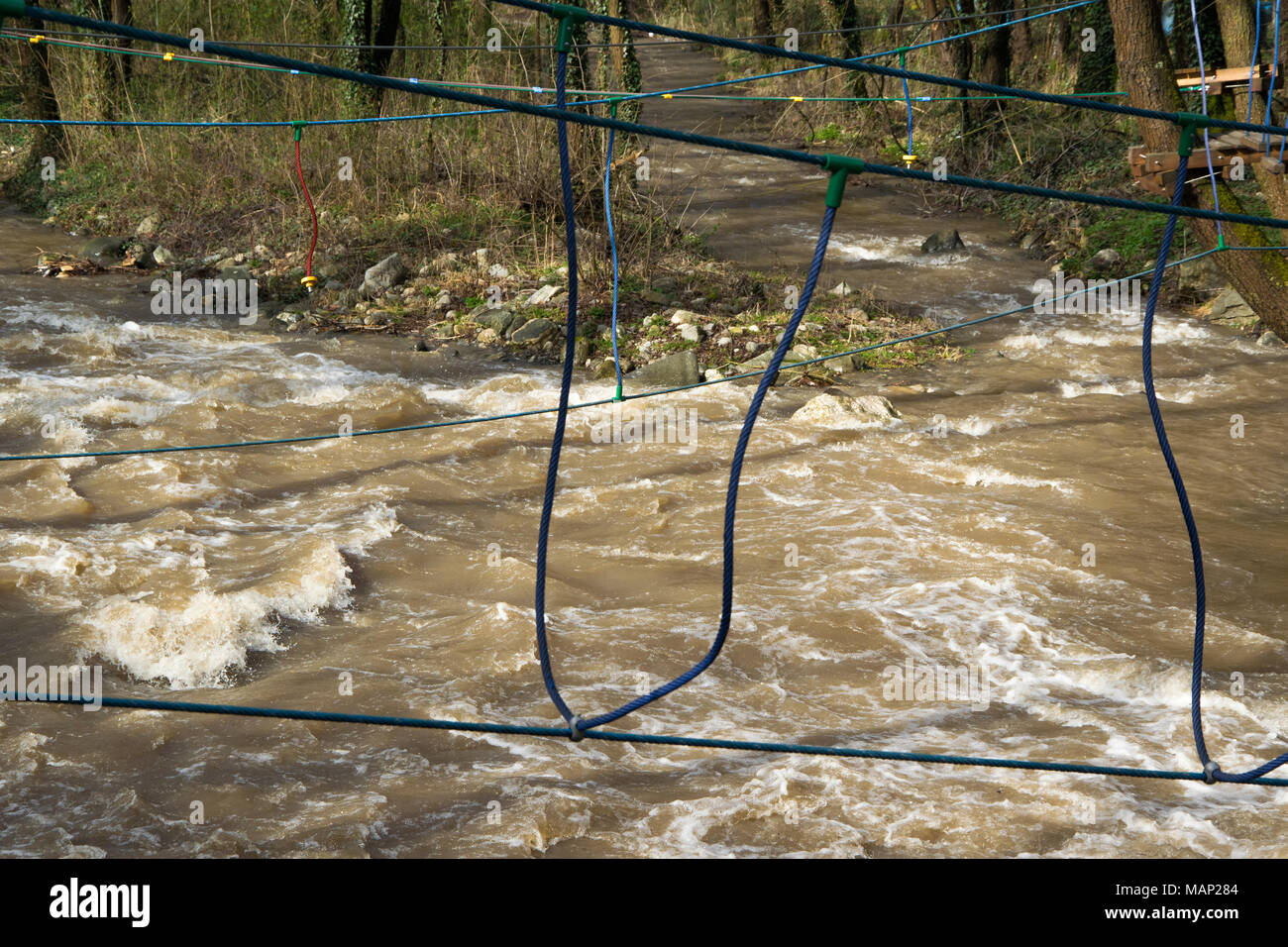 Rope bridge over the fast river, training for survival skills Stock Photo