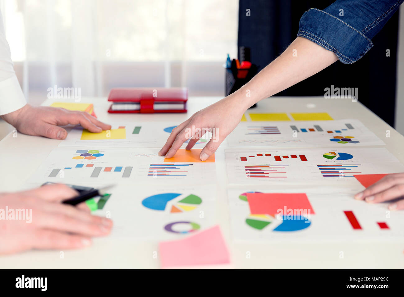 Business colleagues working together and analyzing financial figures on a graphs. Business concept, statistics Stock Photo