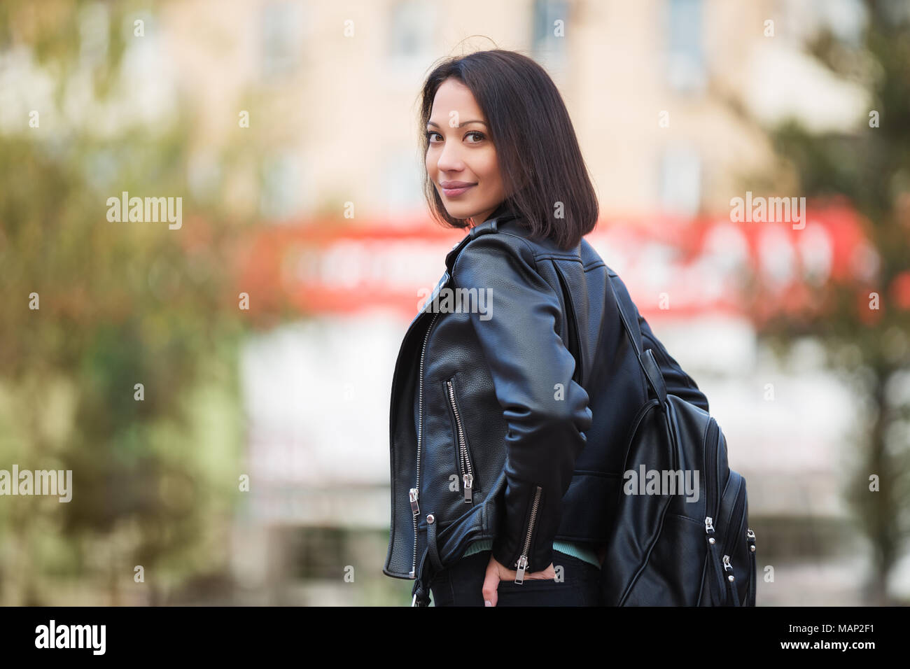 Young fashion woman with backpack walking in city street Stylish female ...