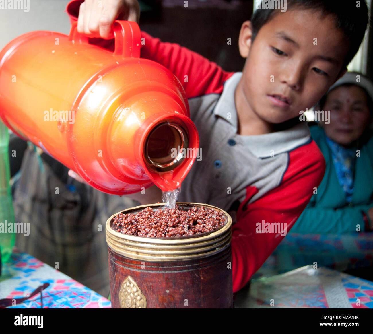 Nepal 2014. Khandbari. Dibbu, millet beer... a young boy pours hot