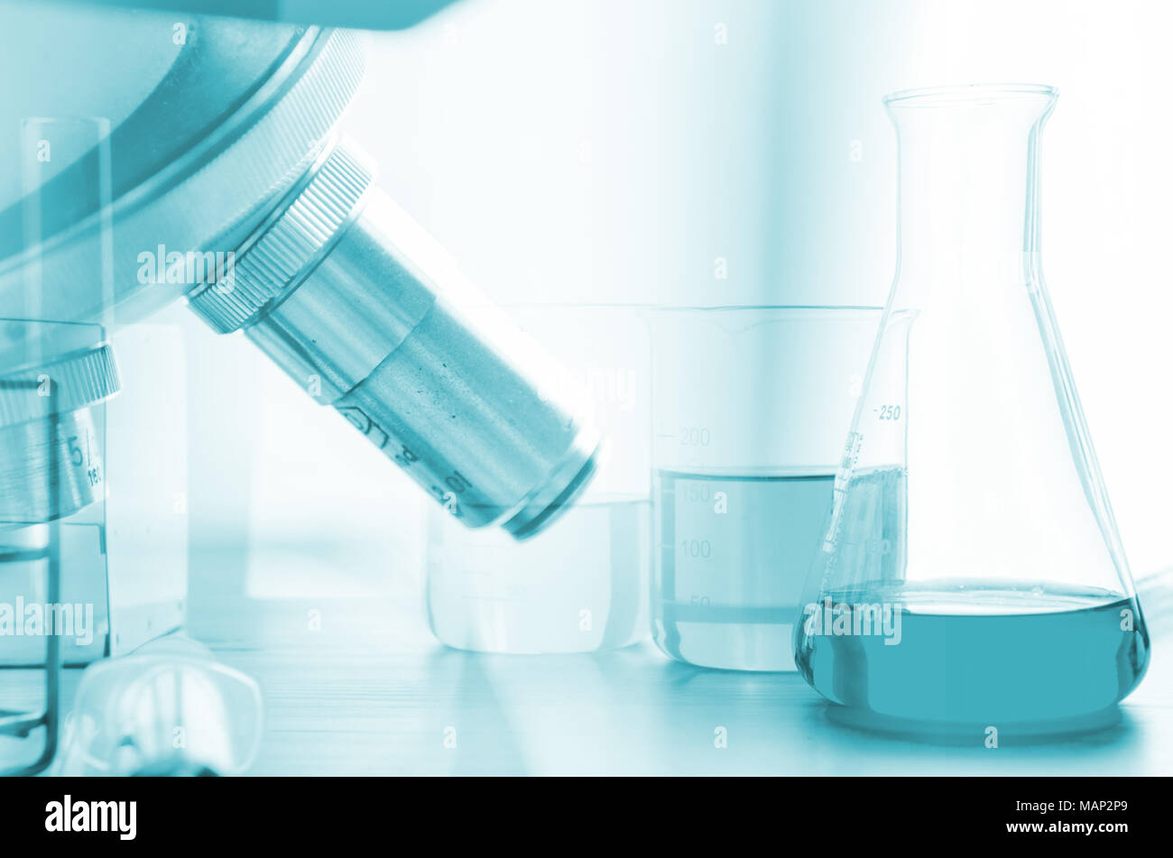 three erlenmeyer flask and microscope , Glassware on science laboratory research and development Stock Photo
