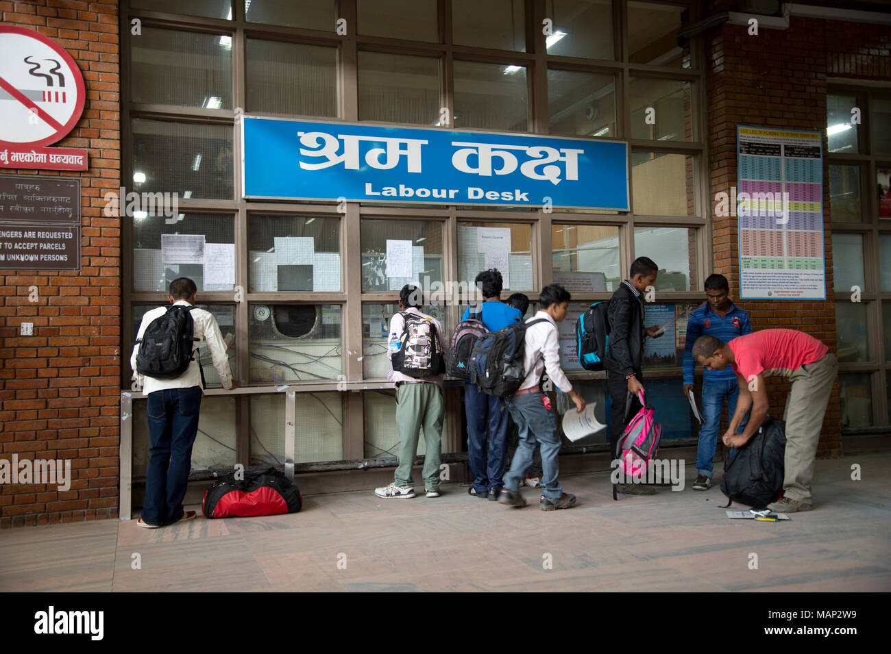 Nepal 2014. Kathmandu airport. Migrant workers about to travel to the Gulf, getting their papers checked at the Labour Desk Stock Photo