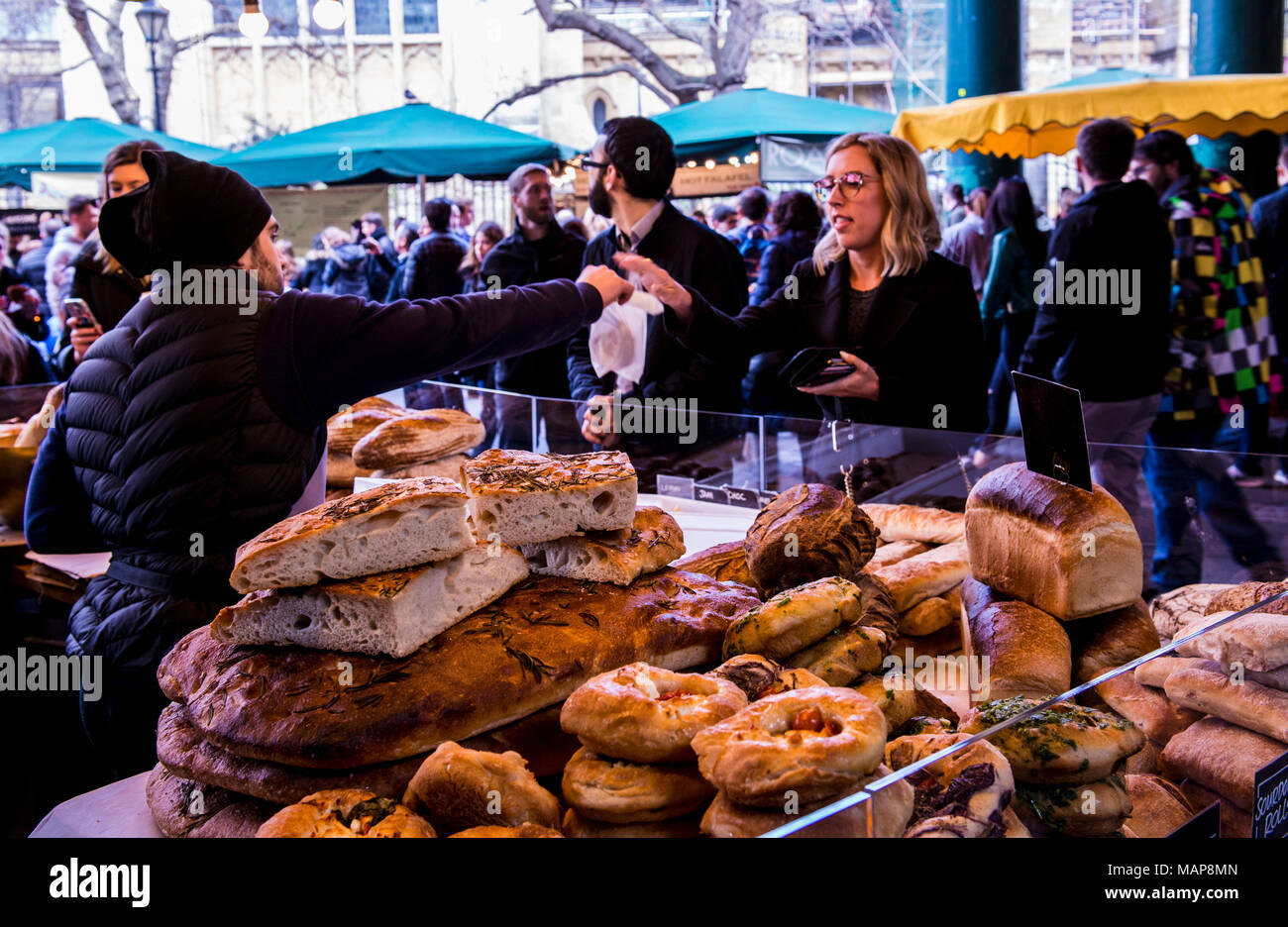 Woman buying food from baker's stall, Borough Market, Southwark, London, England, UK Stock Photo