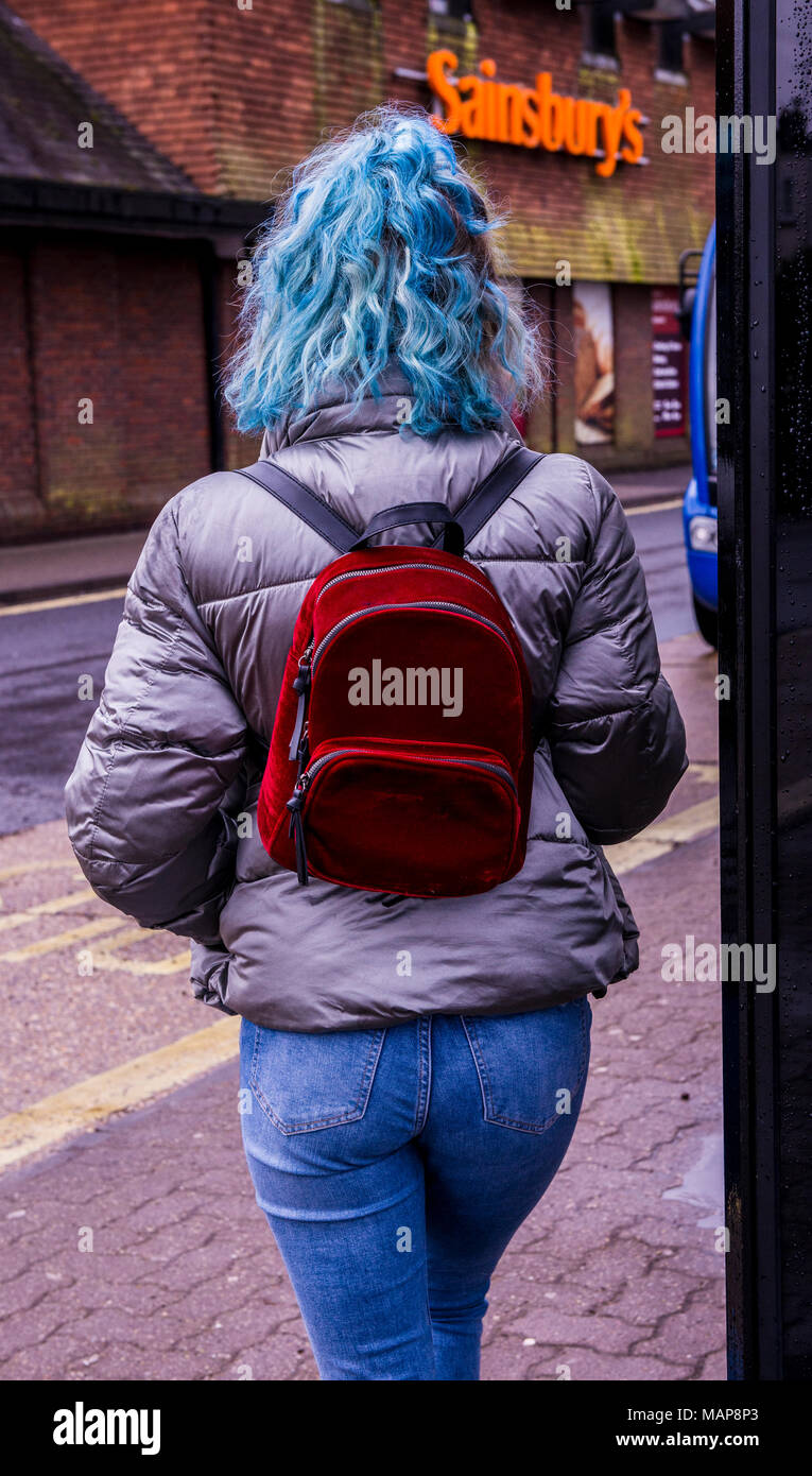 Rear view of woman with dyed blue hair and backpack, Ringwood, Hampshire, UK Stock Photo