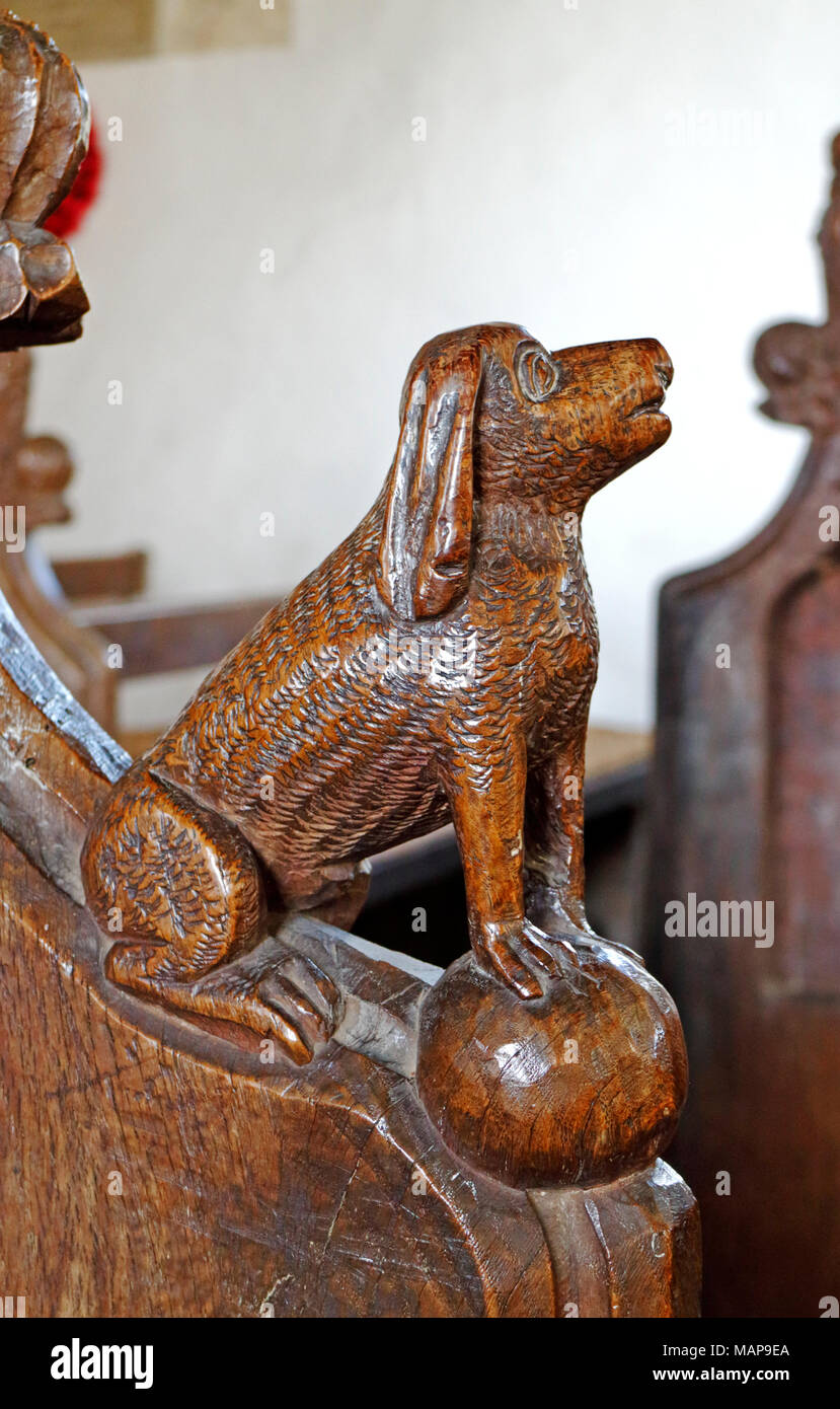 A carved wooden animal on the arm rest of a pew in the church of St Michael at Irstead, Norfolk, England, United Kingdom, Europe. Stock Photo