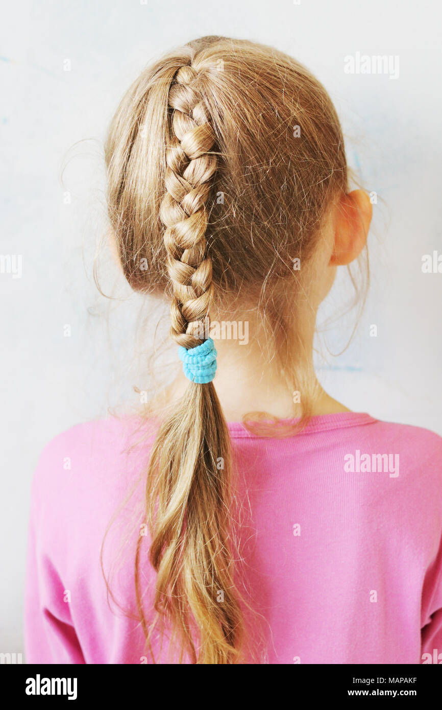 A little white girl with a long plait Stock Photo
