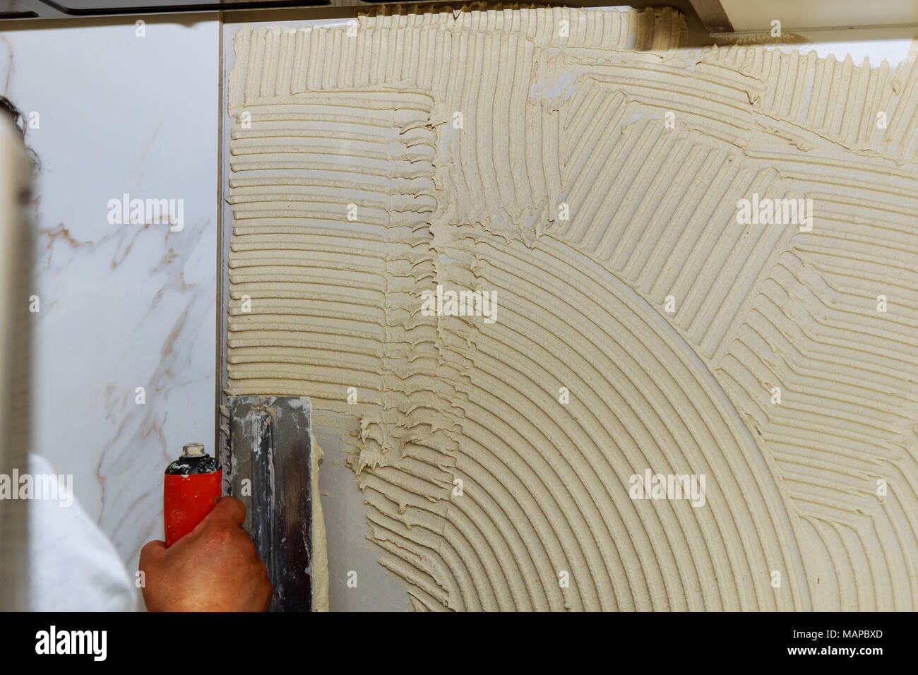 construction mason man hands on tiles work with cement mortar tile
